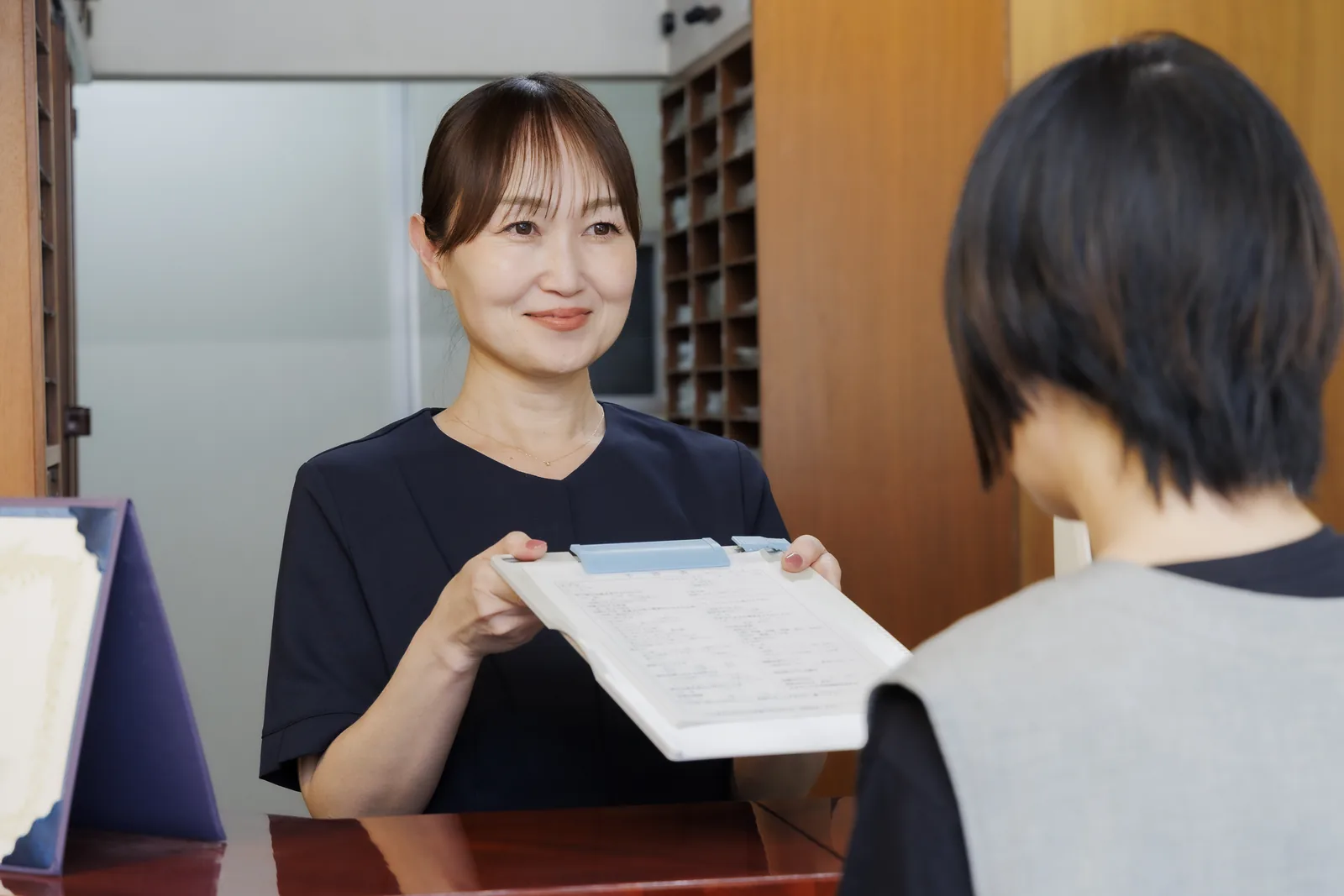 歯科衛生士がモニターの歯の画像を指して説明している様子
