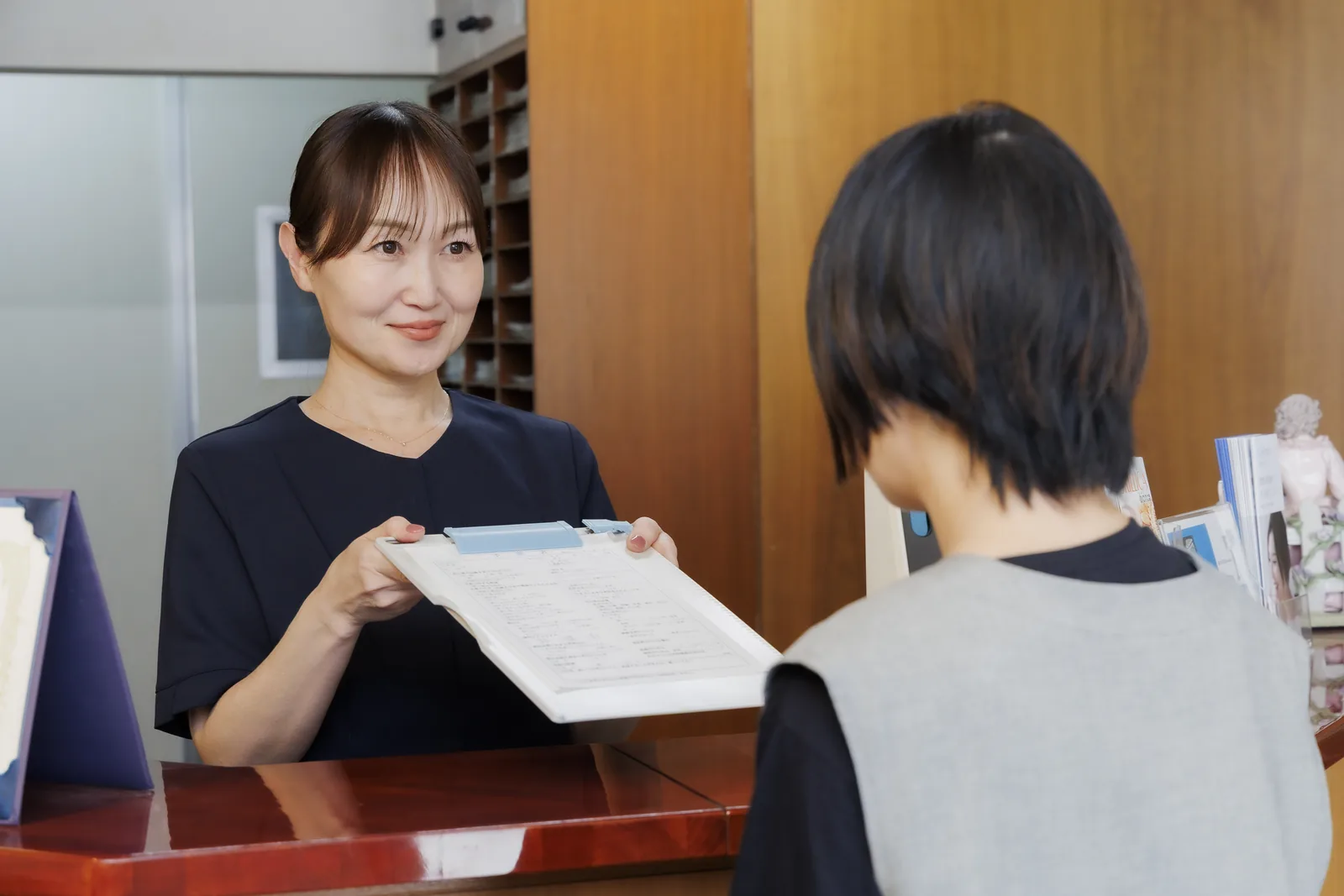 歯科医師がタブレットのレントゲン画像を見せながら患者さまに説明している様子