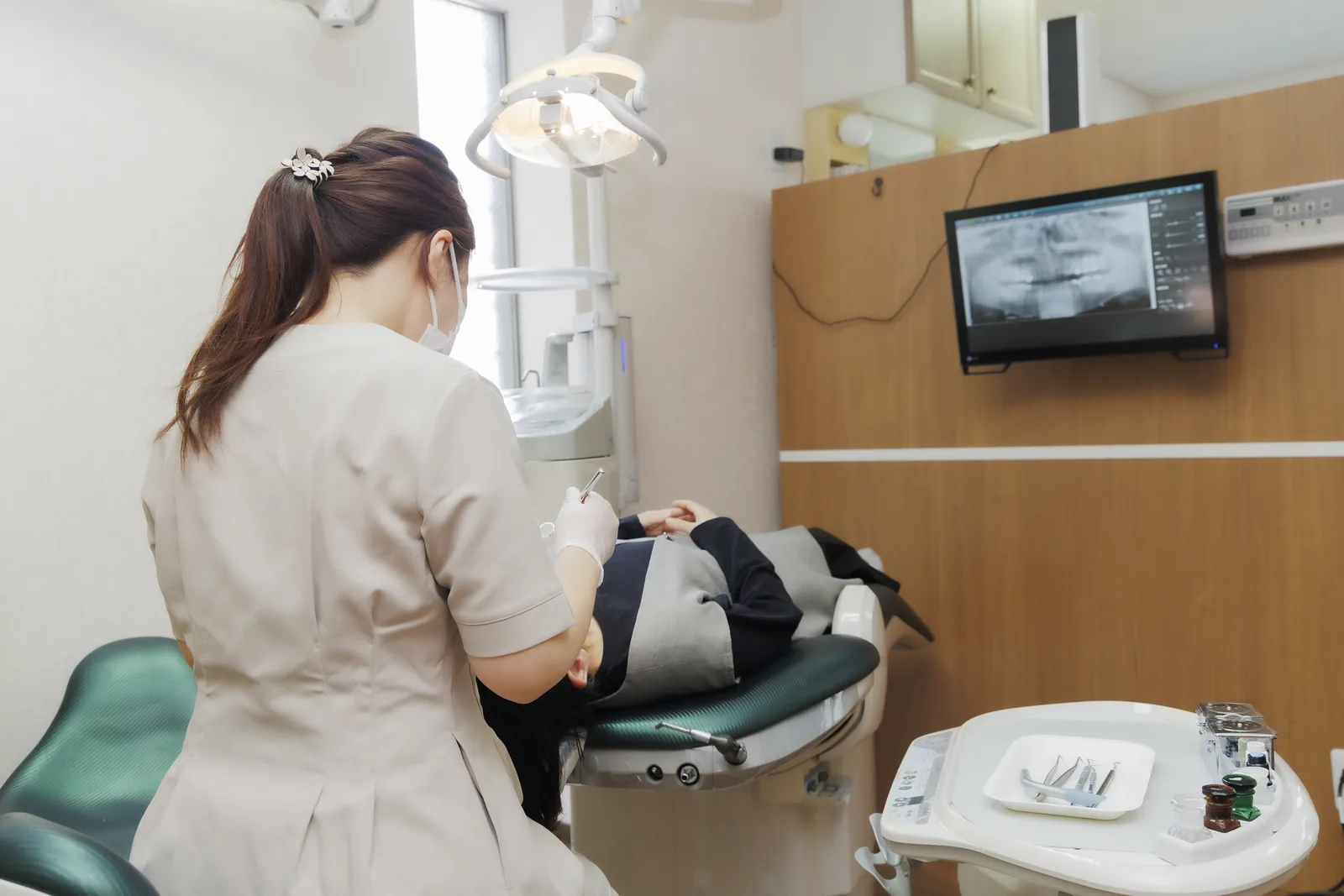 マウスピース型矯正装置とパノラマレントゲンを前に説明する歯科医師