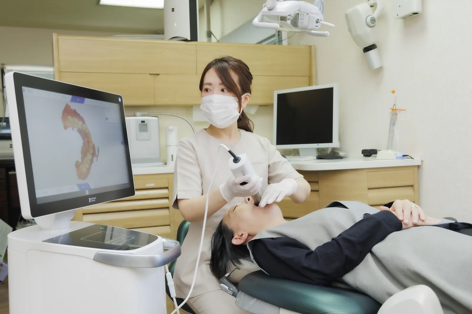 マウスピース型矯正装置とパノラマレントゲンを前に説明する歯科医師