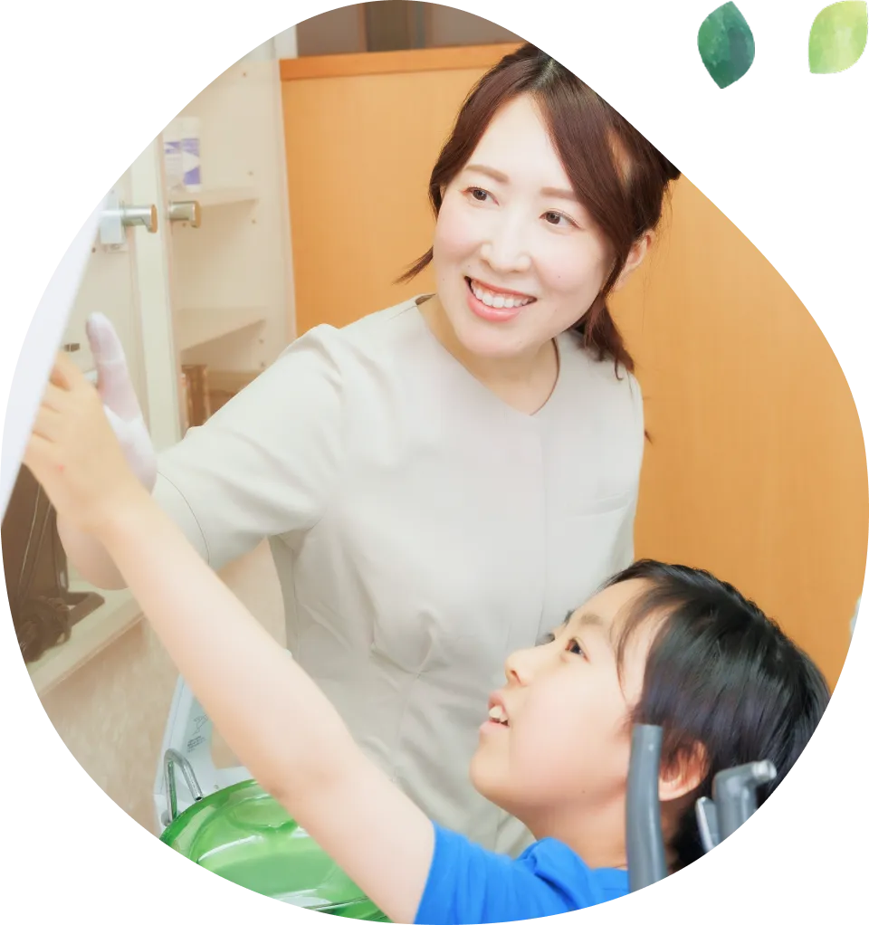 子どもと笑顔で会話している歯科医師