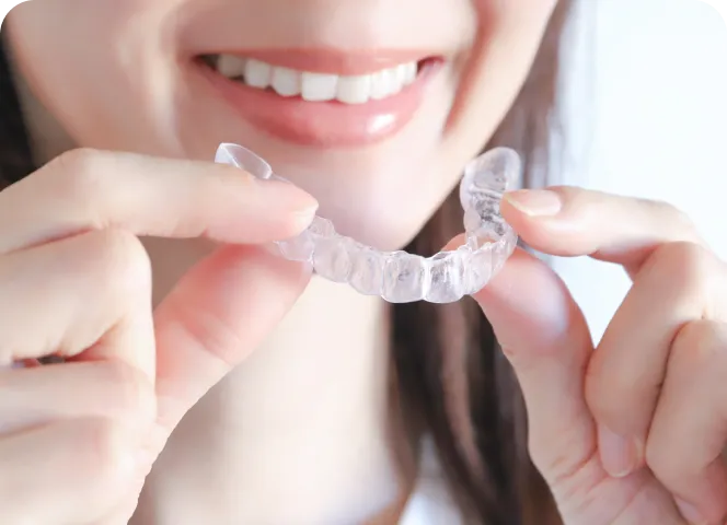 マウスピースを手に持っている女性